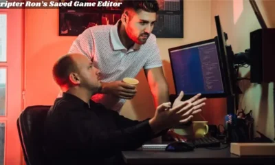 two men sitting at a desk with Game Editor a computer