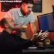 two men sitting at a desk with Game Editor a computer